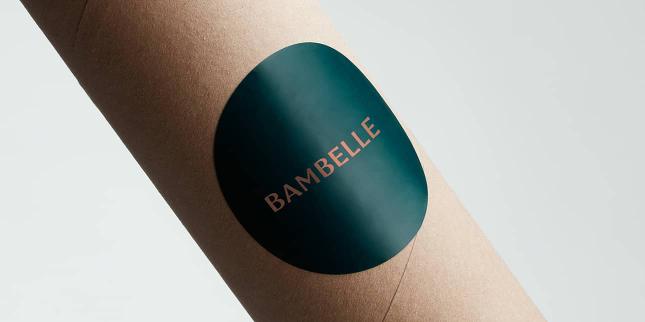 Etiqueta grande Bambelle redonda brillante en un tubo postal de cartón